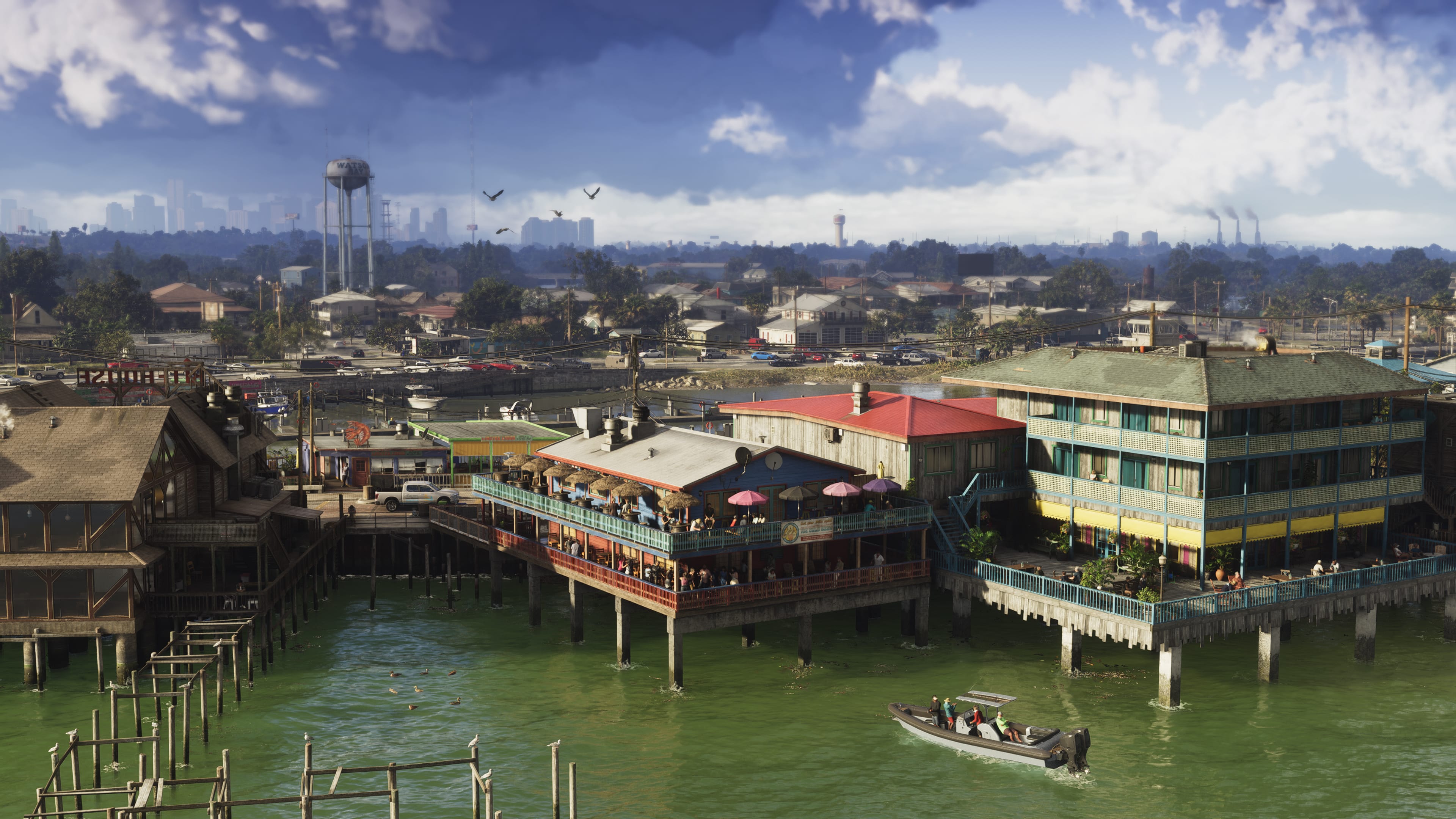 Waterfront settlement in GTA 6’s Grassrivers region, with stilt buildings, boats and wetlands near a distant skyline.